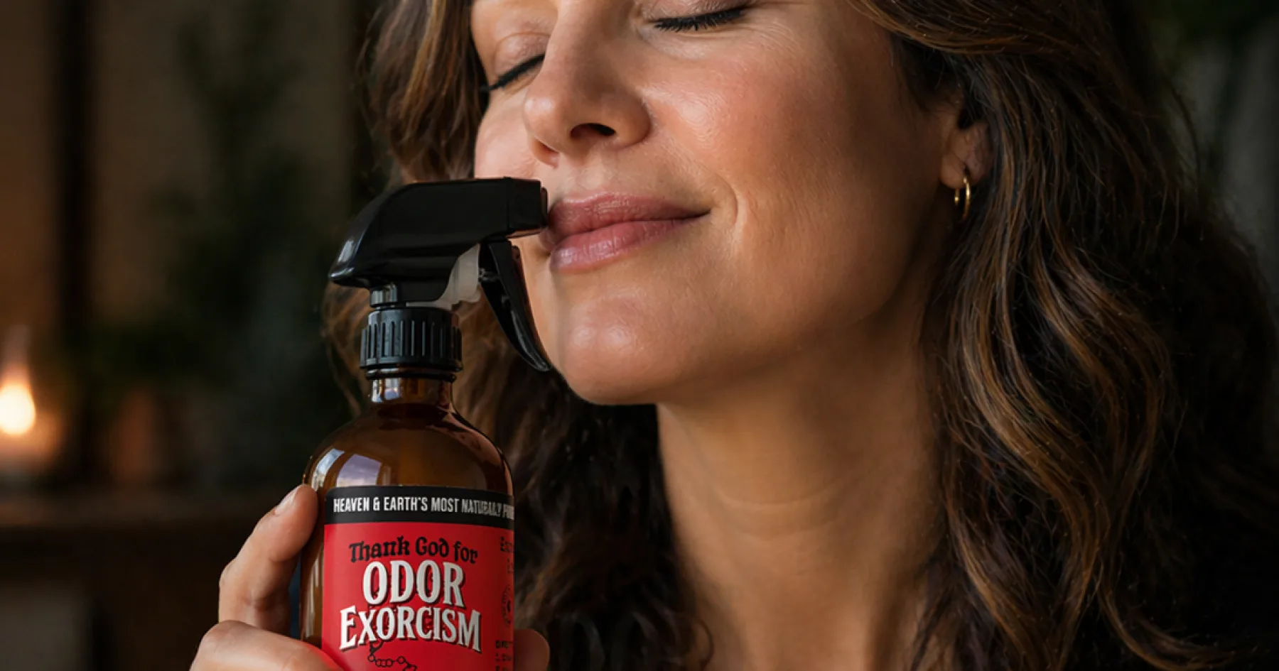A beautiful woman enjoying the pleasant aroma of natural odor eliminator spray from Odor Exorcism.